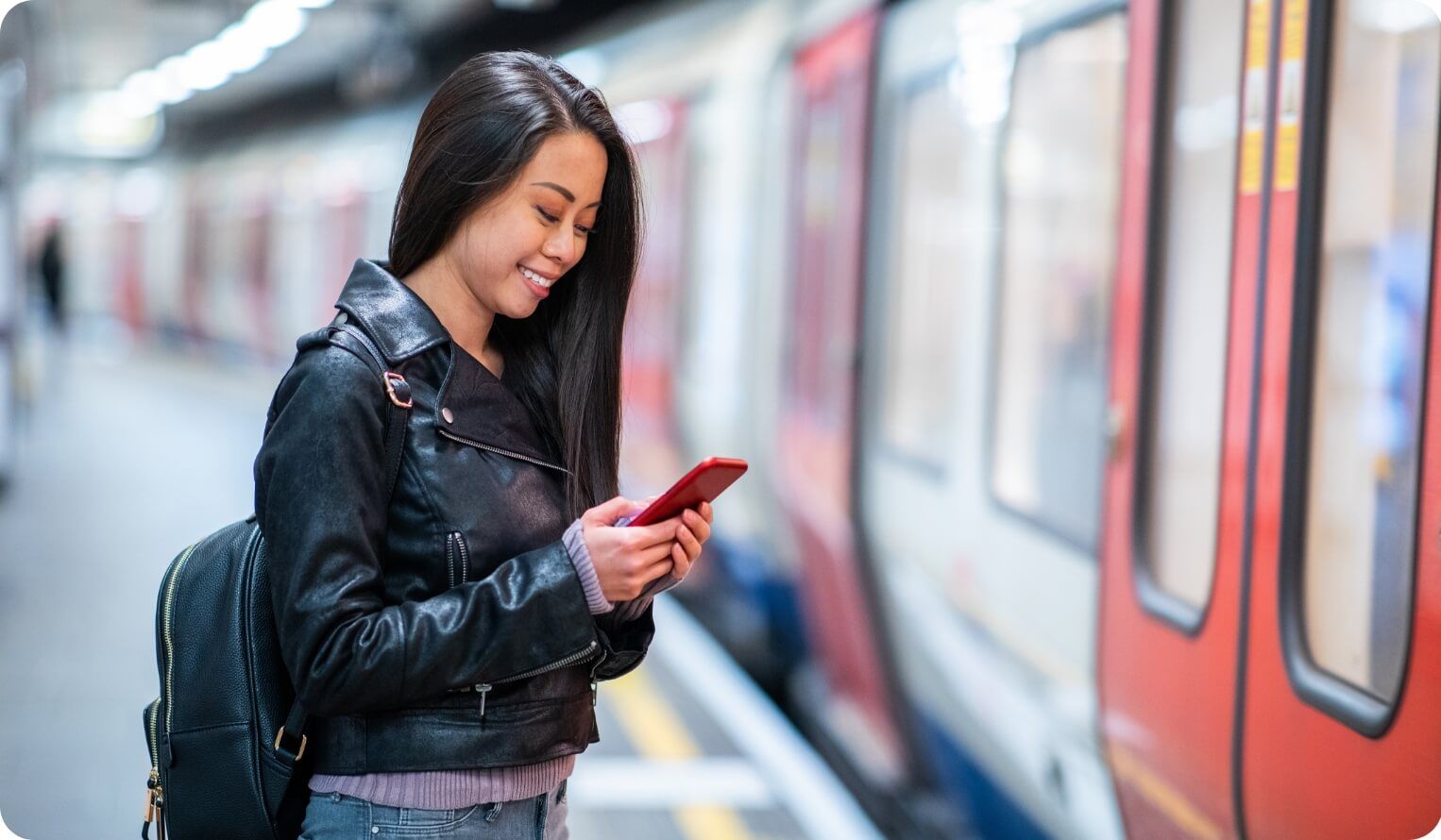 Woman on her phone while waiting for train