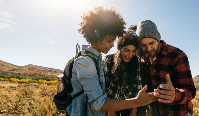 Three people all looking at a phone together