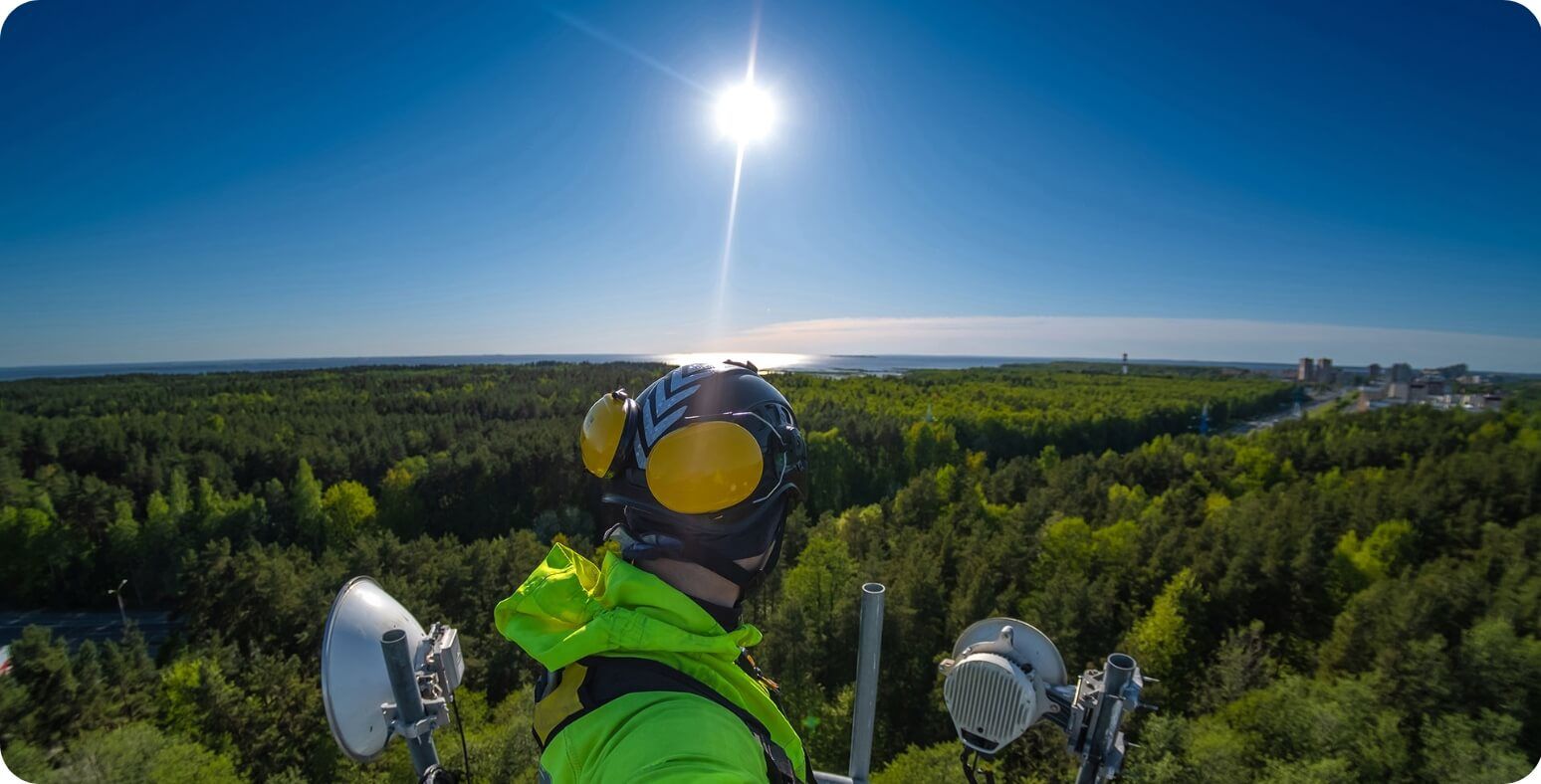 Man taking a picture on a telecoms tower