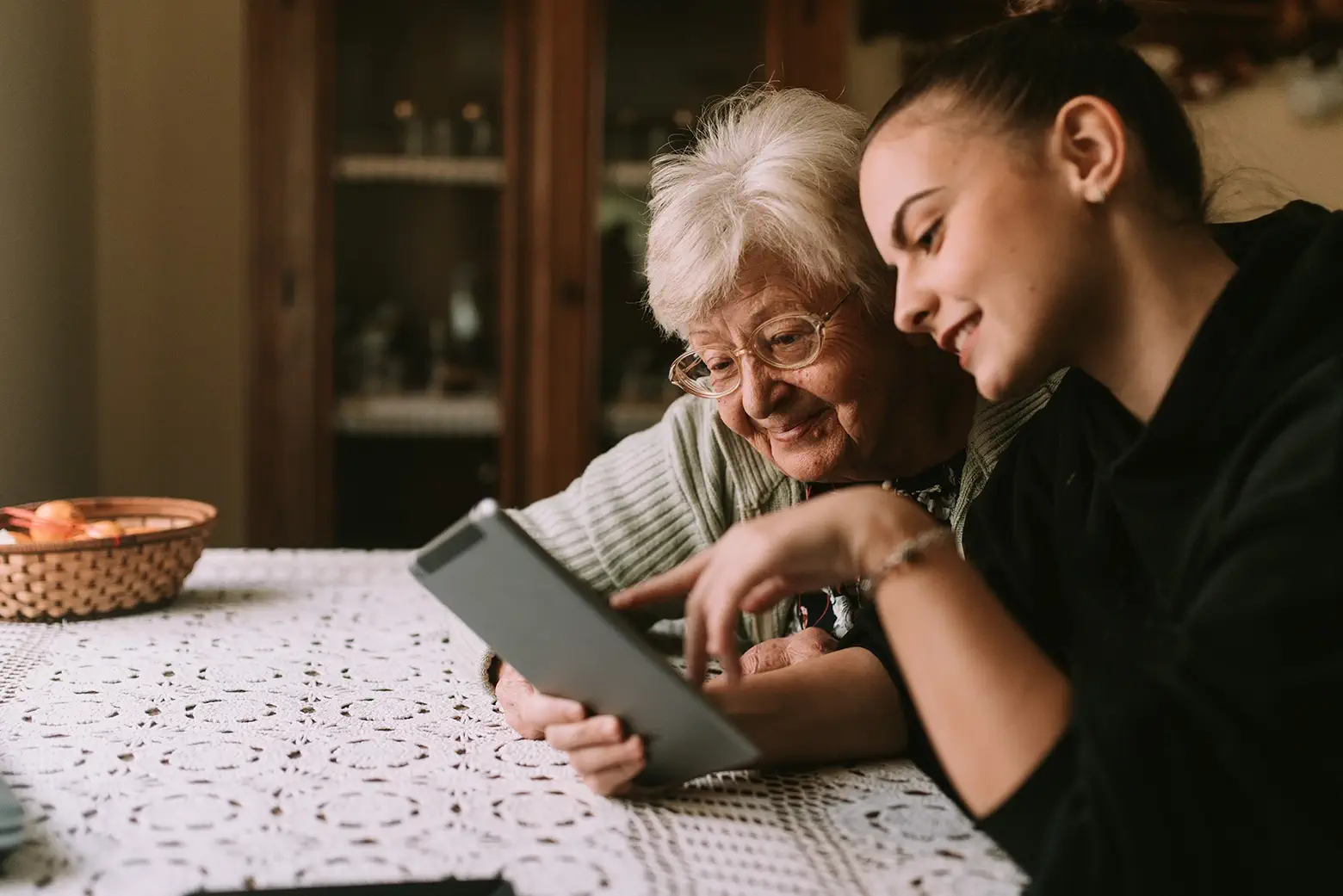 Older and younger people looking at a tablet